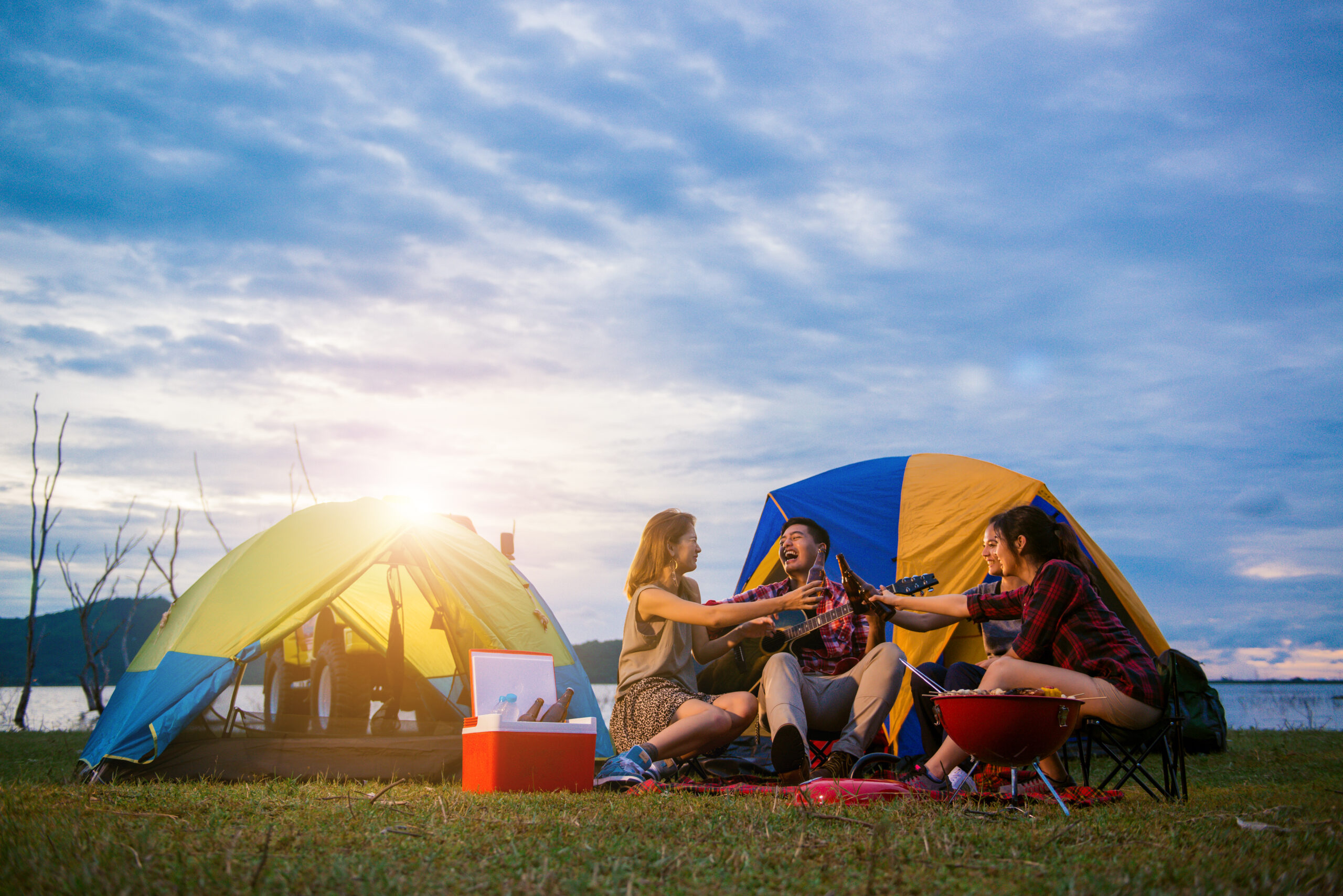 Group of man and woman enjoy camping picnic and barbecue at lake